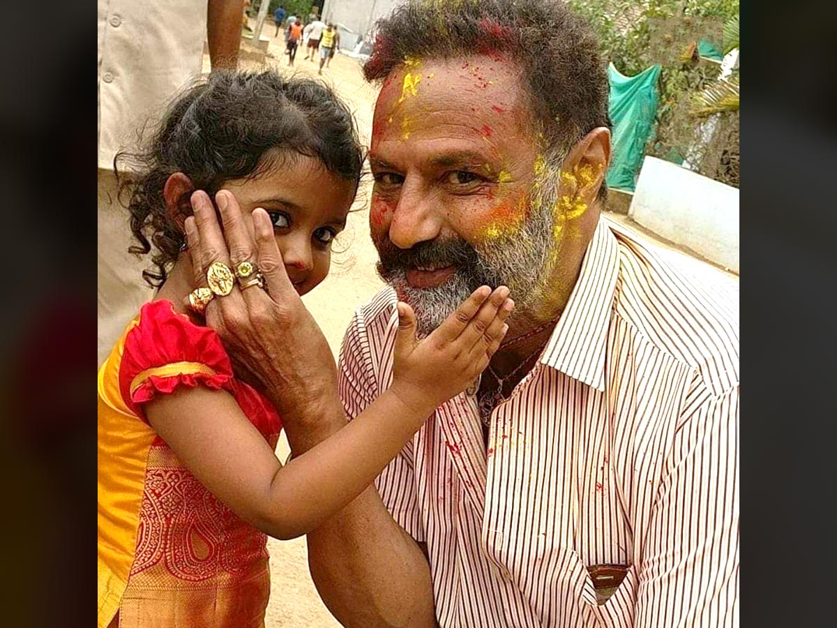 Balakrishna enjoying Holi color on his face